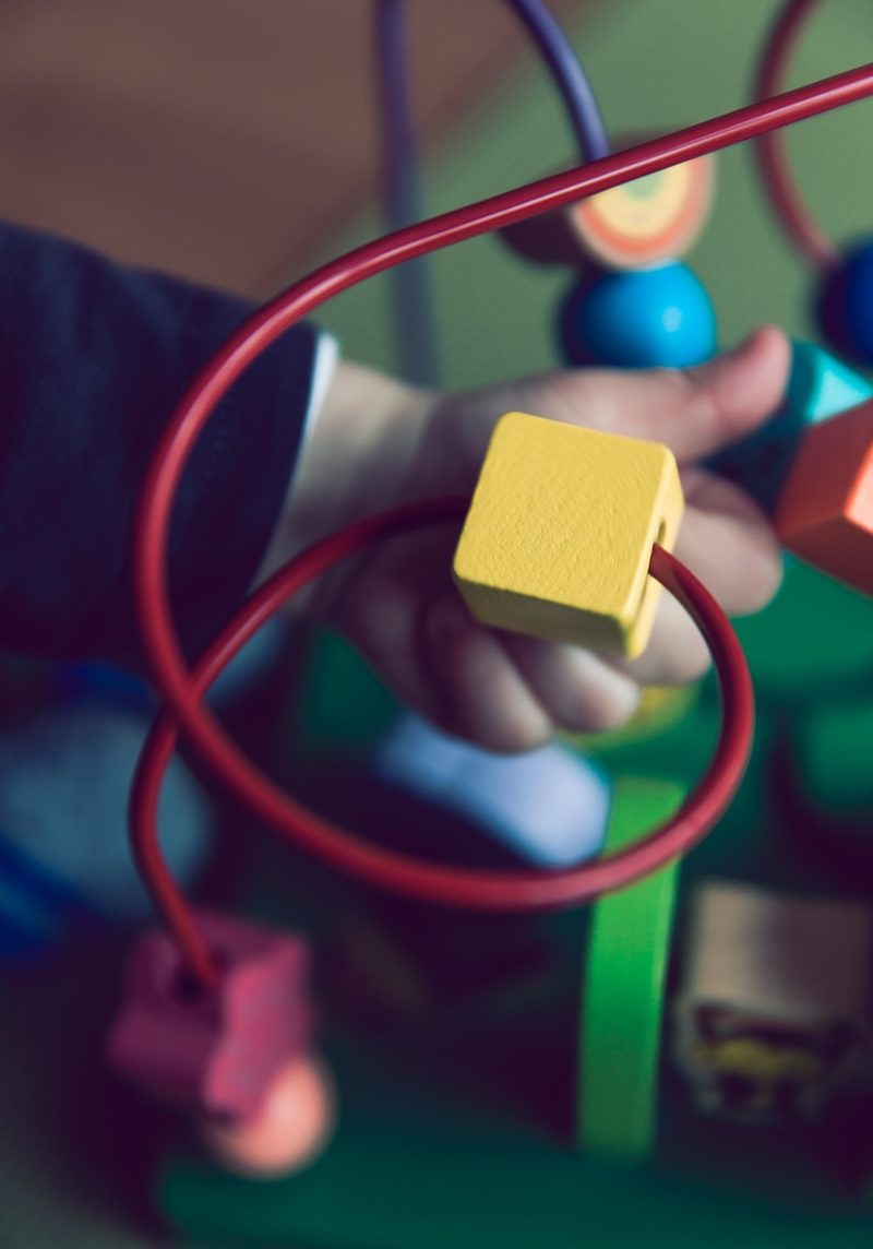 selective focus photo of baby playing activity cube